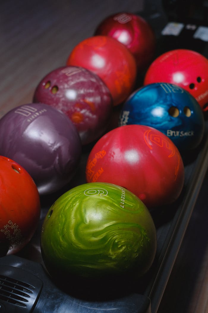Close-up of various colorful bowling balls lined up ready for play.